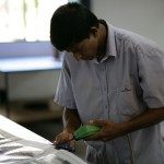 Tilak goes over the entire sails, trimming long threads and burning edges smooth.