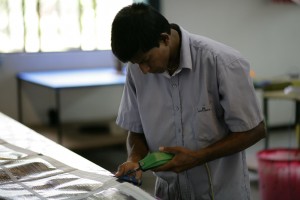 Tilak goes over the entire sails, trimming long threads and burning edges smooth.
