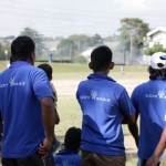 The team watches the two batters up to bat at the wickets.