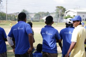 The team watches the two batters up to bat at the wickets.