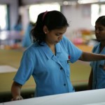 This girl measures a Quantum Optimist sail made in the Ezzy Factory.