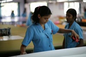 This girl measures a Quantum Optimist sail made in the Ezzy Factory.