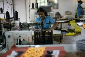 Her co-worker just told her a joke as she was sowing mast bags.