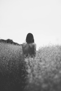 She walks away through the high grass.